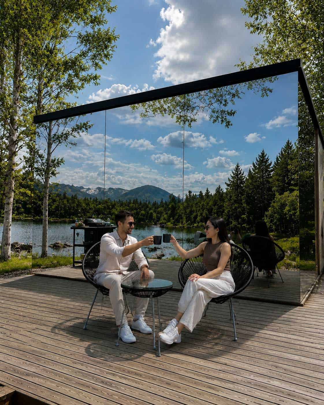 Guests relaxing beside a reflective mirror cabin