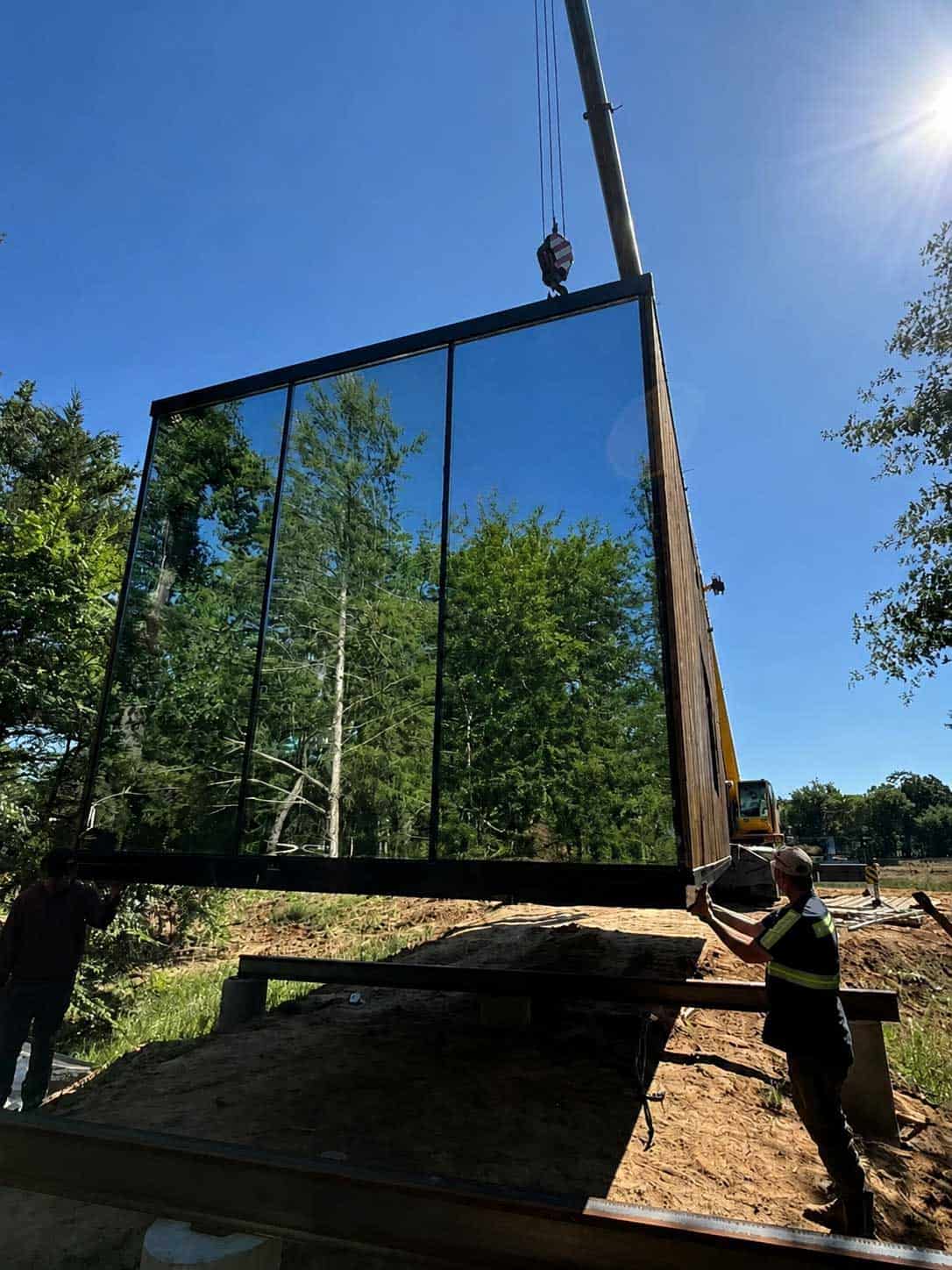 Mirror cabin beside a blue mountain river
